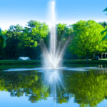 a fountain shoots water from the center of a pond